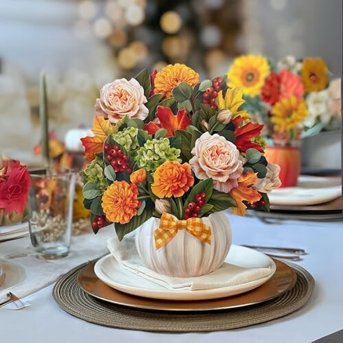 Autumn-themed floral centerpiece with roses and pumpkins on a table.