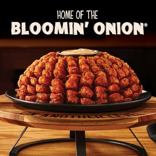 Bloomin' Onion appetizer on a wooden stand with dipping sauce.