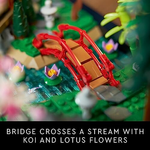 Toy bridge over a stream with koi and lotus flowers