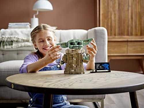 Child assembling Yoda Lego set at a table