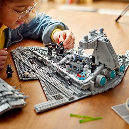 Child assembling a detailed LEGO spaceship model.