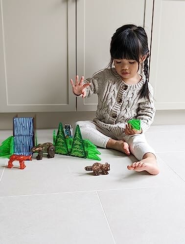 Child playing with toy animals and building blocks on the floor.