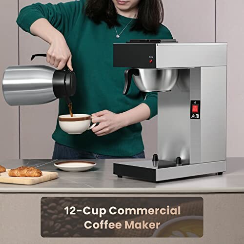 Person pouring coffee from carafe next to commercial coffee maker.