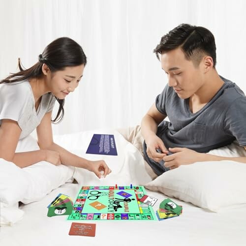 Couple playing a board game on a bed.