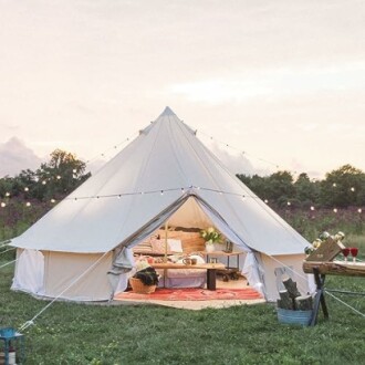 Cozy glamping tent with lights in a field