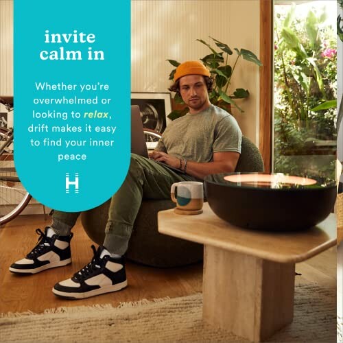 Man sitting on a bean bag with a laptop in a cozy living room.