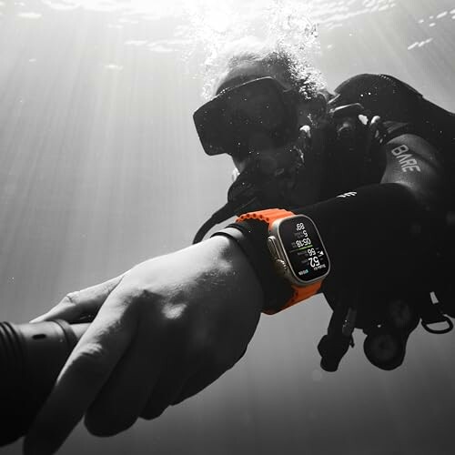 Scuba diver underwater wearing a smartwatch with orange band