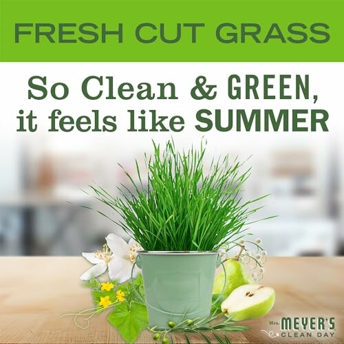 Fresh cut grass in a pot with flowers and fruit, promoting a clean and green summer vibe.