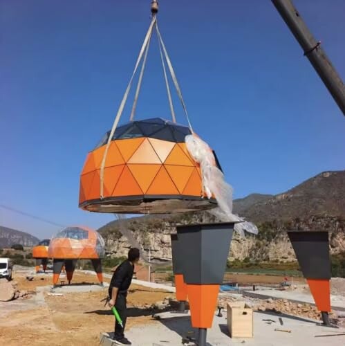 Geodesic dome being installed with crane at construction site