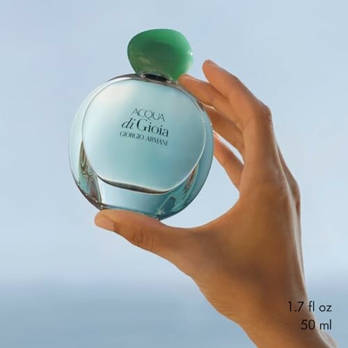 Hand holding Giorgio Armani Acqua di Gioia perfume bottle