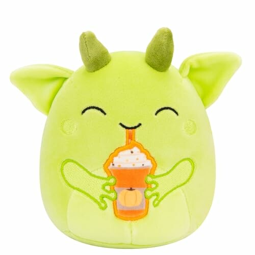 Green plush toy with horns holding a pumpkin drink