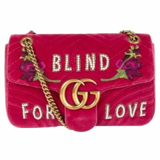 Pink Gucci shoulder bag with floral embroidery and 'Blind for Love' text.