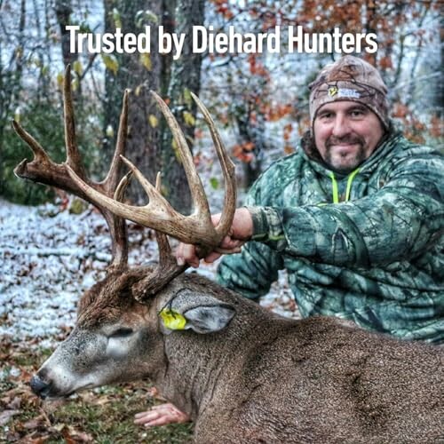 Hunter posing with a deer in a snowy forest.