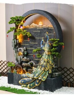 Decorative indoor peacock water fountain with rocks and plants