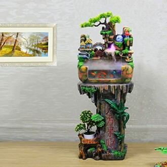 Indoor decorative water fountain with small houses and greenery.