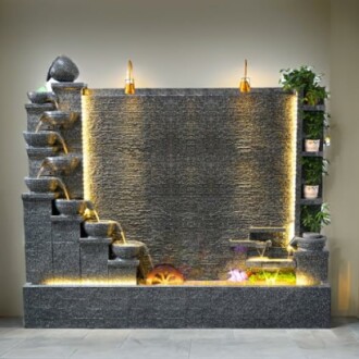 Indoor decorative water fountain with cascading bowls and plants.