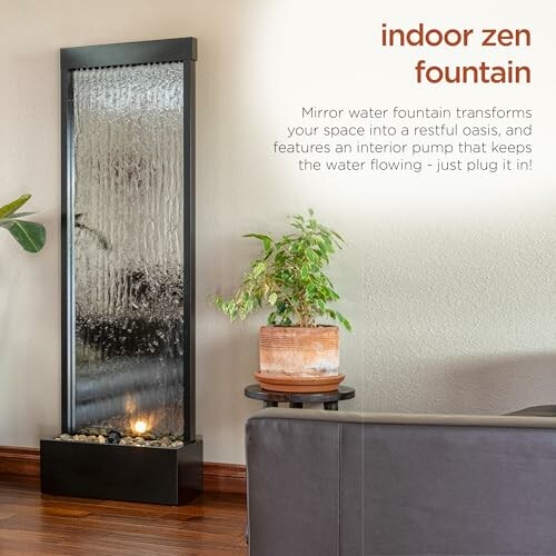 Indoor zen fountain with mirror and plant on side table.