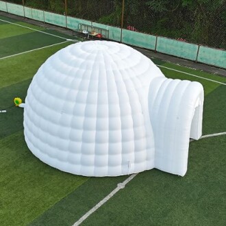 Large white inflatable igloo on a sports field