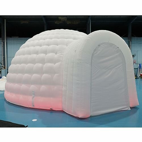 Inflatable white igloo-shaped tent with arched entrance.