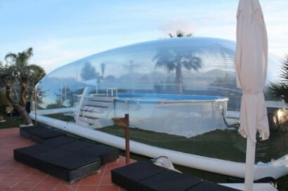 Inflatable dome covering a pool in a backyard.