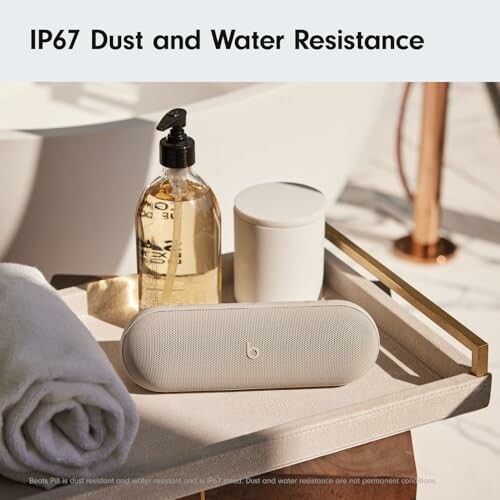 Wireless speaker with IP67 dust and water resistance, placed on a tray with soap and a towel.