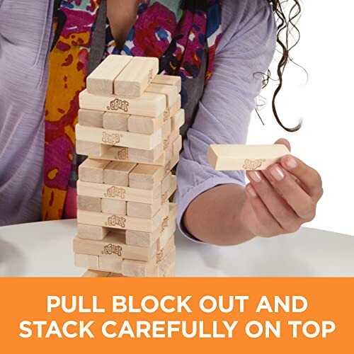 Person playing Jenga, pulling a block from the tower.