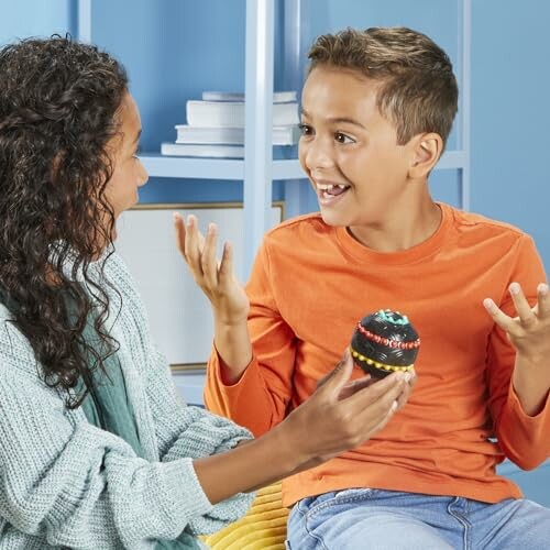 Two children smiling and talking while holding a colorful toy.