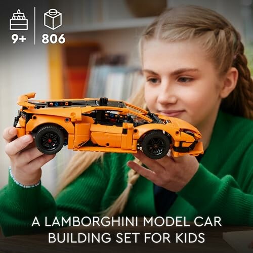 Child holding a model Lamborghini car building set.