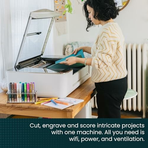 Person using a laser cutter machine for crafting projects.