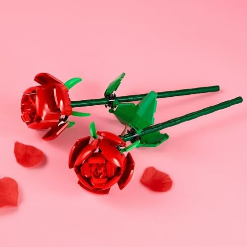 Two red LEGO roses on a pink background with petals