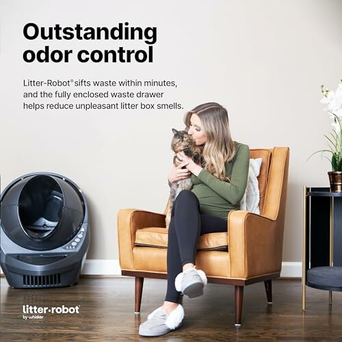 Woman sitting with cat beside Litter-Robot, highlighting odor control feature.