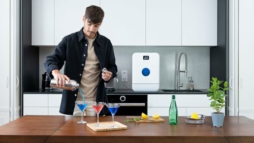 Man pouring cocktails in a modern kitchen setting.