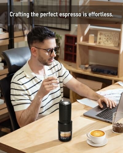 Man using a portable espresso maker at a desk.