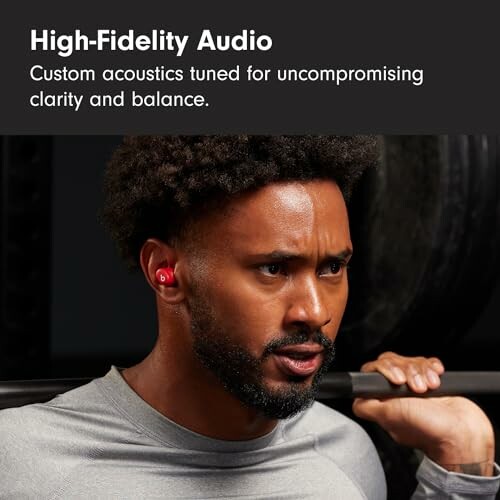 Man wearing earbuds lifting weights with high-fidelity audio text.