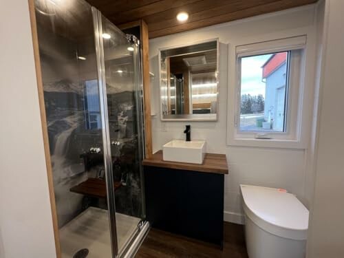 Modern bathroom with shower, sink, and toilet.