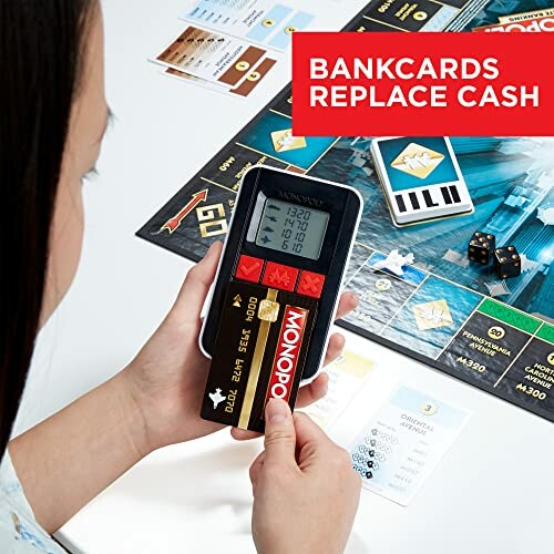 Person holding electronic banking device for Monopoly game.