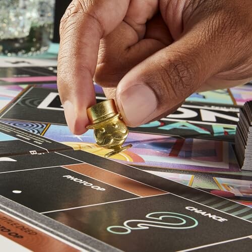 Close-up of a hand moving a Monopoly game piece on the board.