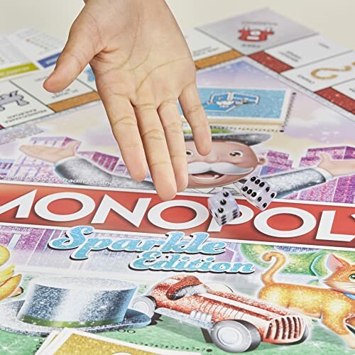 Hand rolling dice on Monopoly Sparkle Edition board.