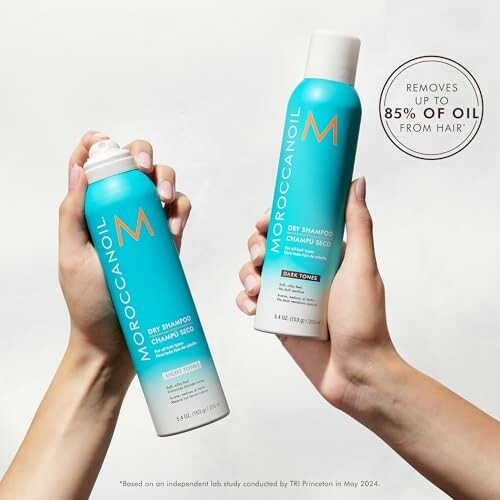 Hands holding Moroccanoil dry shampoo bottles with text about oil removal.