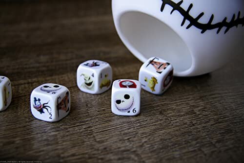 Themed dice with Halloween characters spilling from a decorated cup.