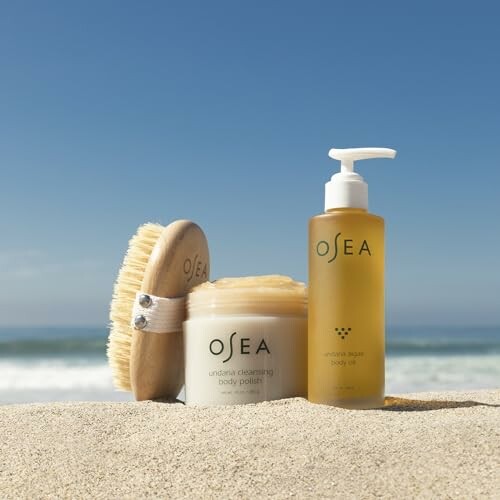 OSEA body polish and body oil on a sandy beach with a sea view