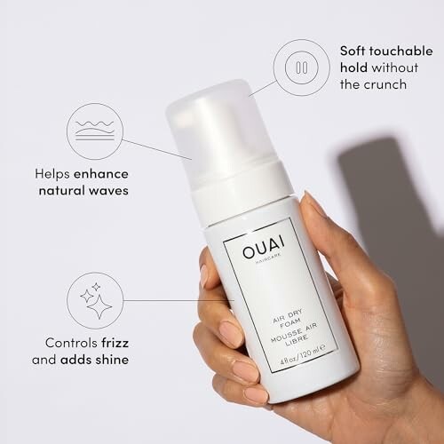 Hand holding Ouai Air Dry Foam with descriptive icons highlighting benefits.