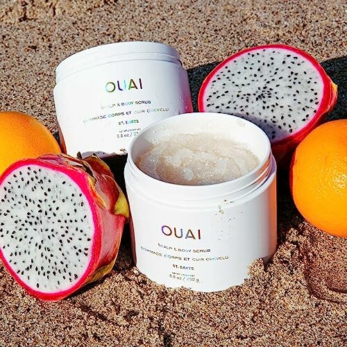 Ouai scalp and body scrub with dragon fruit and oranges on sand