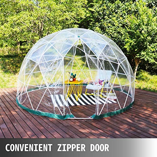 Transparent geodesic dome tent with chairs and table inside on a wooden deck.