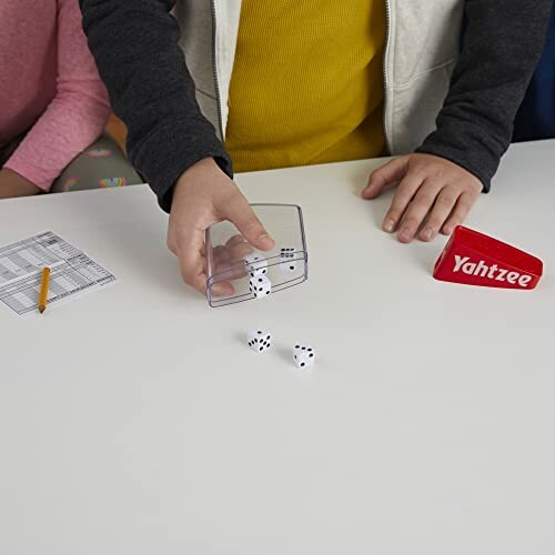 Children playing Yahtzee with dice and score sheet on a table.