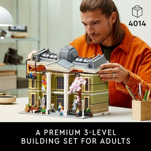 Person assembling a 3-level building set for adults.