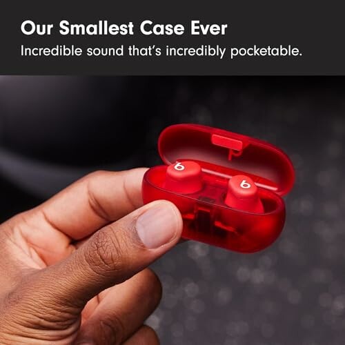 Hand holding red earbuds in a small case