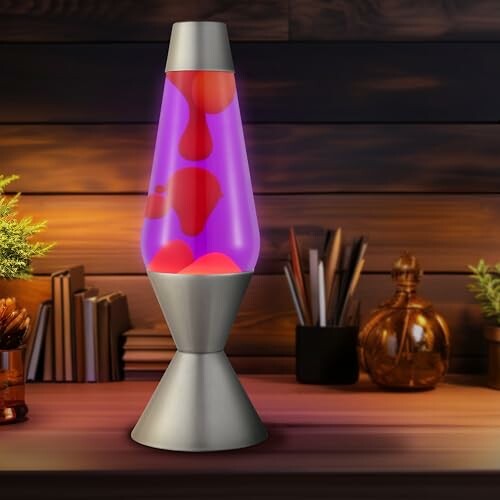 Colorful lava lamp on a wooden desk with books and plants.