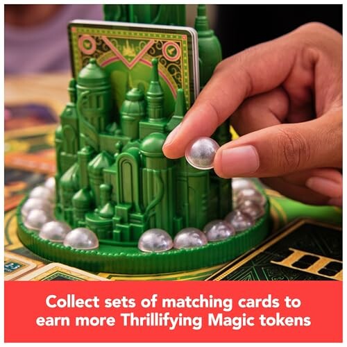 Hand placing token on board game with green castle structure.