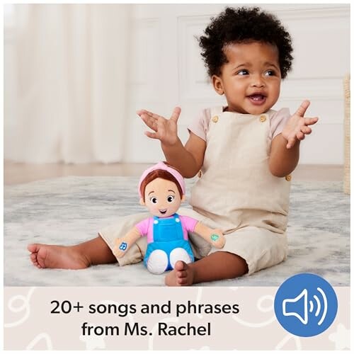 Toddler sitting with a toy that plays songs and phrases.